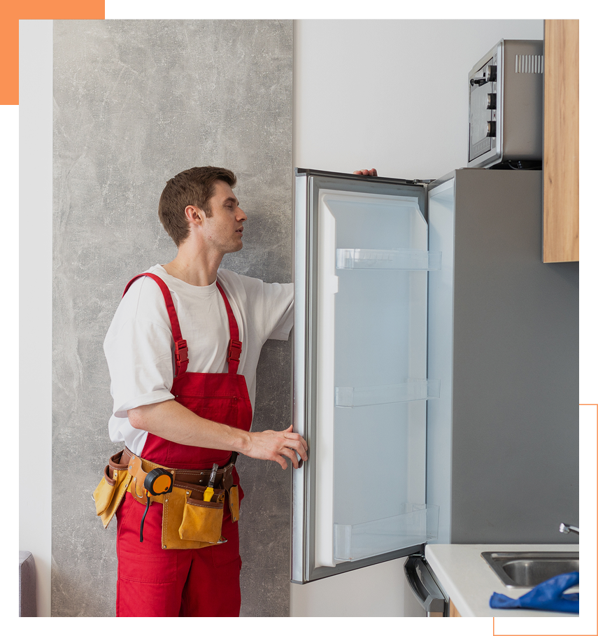 Appliance repair technician inspecting open refrigerator during service visit.