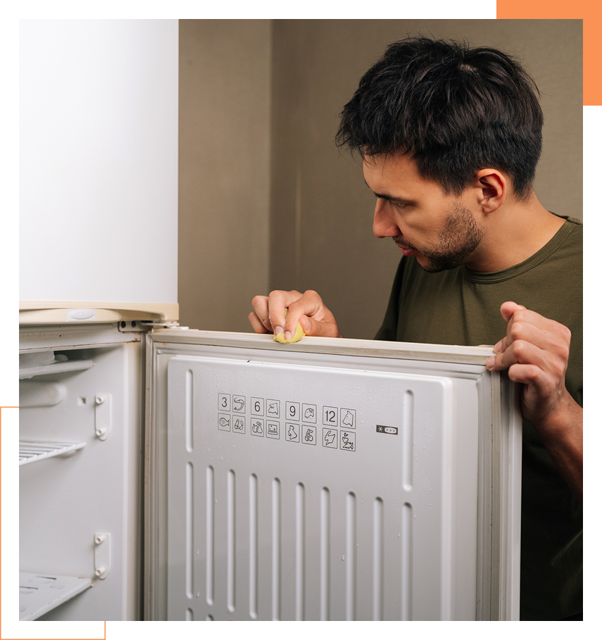 Homeowner cleaning refrigerator door seal gasket.