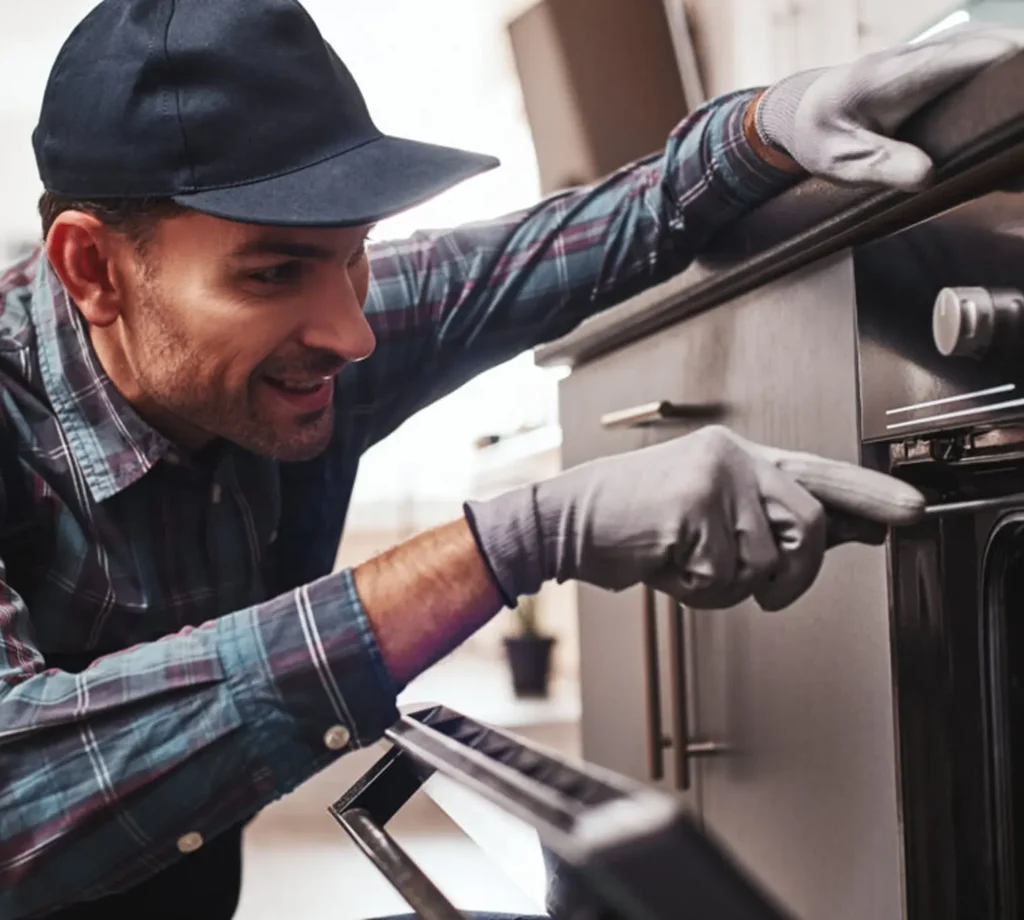 Man wearing gloves checking an oven.